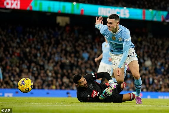 Sheffield United's goalkeeper Wes Foderingham attempts to stop Manchester City's Phil Foden during the English Premier League soccer match between Manchester City and Sheffield United at the Etihad stadium in Manchester, England, Saturday, Dec. 30, 2023. (AP Photo/Dave Thompson)