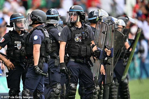 Riot police were pictured after Moroccan fans invaded the pitch after Argentina's last goal